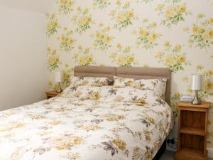 a bedroom with a bed with a floral wallpaper at 17 Riverside in Oakamoor