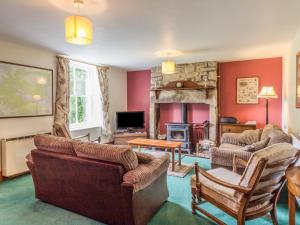 a living room with a couch and a fireplace at Old Hall Cottage in Greenhaugh