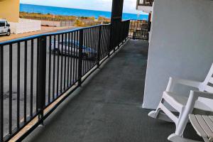 uma varanda com duas cadeiras brancas e o oceano em Grandview em Ocean City