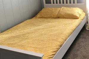 ein Bett mit einer gelben Decke darüber in der Unterkunft Grandview in Ocean City