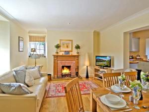 a living room with a couch and a fireplace at The Old Farmhouse in Bowsden