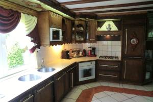 a kitchen with wooden cabinets and a sink and a window at B&B Luttelhof, de goedkoopste in de regio ! in Luttelgeest