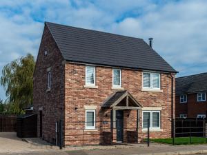 una casa de ladrillo rojo con techo negro en Farm View House, en Melton Mowbray