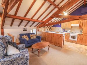 a kitchen and living room with blue chairs and a table at The Old Hayloft in Great Edston