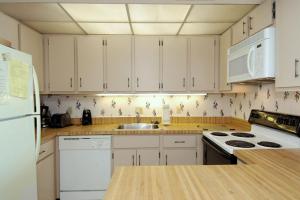 オーシャンシティにあるGolden Sandsの白いキャビネットと白い冷蔵庫のあるキッチン