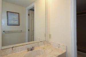 オーシャンシティにあるGolden Sandsの洗面台と大きな鏡のあるバスルーム