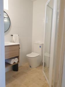 a bathroom with a toilet, sink and tub at Sandpiper Motel Ulladulla in Ulladulla