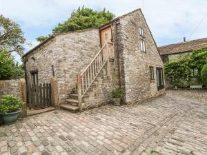 an old brick building with a staircase on it at Barn Cottage in Buxton