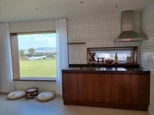 a kitchen with a large window with a view of a field at Stay Gyeongju in Gyeongju