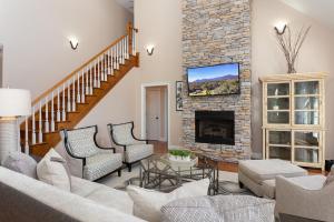 a living room with a stone fireplace at Luxurious House with Pool Near Asheville by Mighty Tree Properties in Leicester