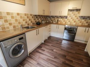 a kitchen with a washer and a sink and a dishwasher at 2 Wheatsheaf Yard in Morpeth