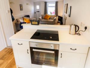 a kitchen with a stove top oven in a caravan at Copper Cottage in Ingleton