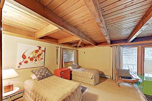 スノーマス・ビレッジにあるWood Road Houseのベッドルーム1室(ベッド2台、椅子付)