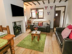 a living room with a couch and a table at Changegate Cottage in Keighley