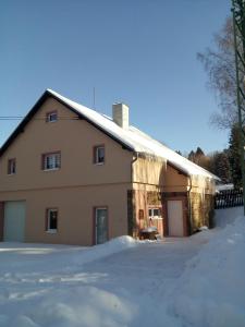 ein Haus mit Schnee davor in der Unterkunft Chalupa ve Vejprtech in Vejprty