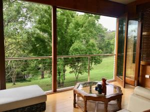 Eumundi Guesthouse and B&B في يوموندي: غرفة معيشة مع نافذة كبيرة وطاولة قهوة