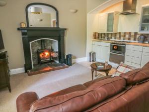 a living room with a couch and a fireplace at The Cells in Ingleton 