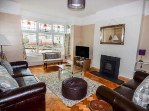 a living room with leather furniture and a fireplace at Pen Hill in Llantwit Major