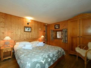 a bedroom with a bed in a room with wooden walls at Chalet La Plagne Montchavin Les Coches, 5 pièces, 13 personnes - FR-1-329-67 in La Plagne Tarentaise