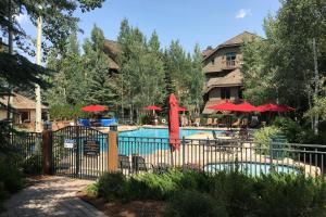 a pool with red umbrellas and a resort at Sawatch Townhouse C8 in Edwards