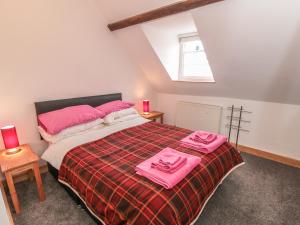 スカーバラにあるTinsley Cottageのベッドルーム1室(ピンクのタオルが付いたベッド1台付)