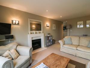 a living room with two couches and a fireplace at Long Meadow in Heyshott