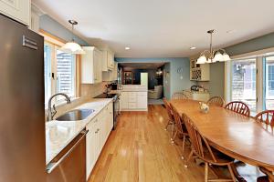 eine Küche und ein Esszimmer mit einem großen Holztisch in der Unterkunft Wharf Side Hideout in Hyannis