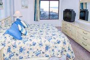 a bedroom with a bed and a tv and a window at Phoenix 406 - A Wave From it All in Ocean City
