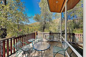 a patio with tables and chairs on a balcony at Aspen Meadows Resort 111 in Aspen