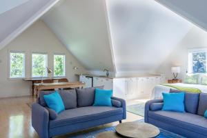 sala de estar con 2 sofás azules y 1 cama en Blackfish Bungalow, en Wellfleet
