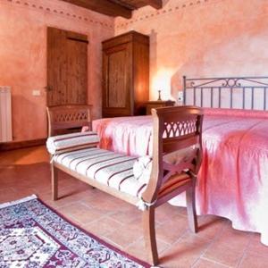 Dormitorio con cama con banco en Podere Lamaccia - bed and kitchinette, en Cetona