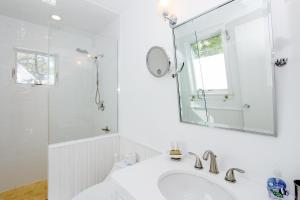 Un baño blanco con lavabo y espejo. en Blackfish Bungalow, en Wellfleet 36 fotos más