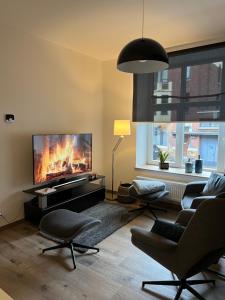 ein Wohnzimmer mit einem großen Flachbild-TV in der Unterkunft Les Duplex de la Place des Ecoles in Spa