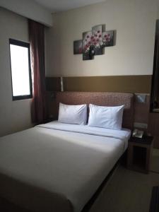 a bedroom with a large bed with white pillows at AMS PENTHOUSE in Jakarta