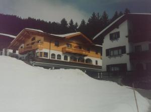 トゥクスにあるLandhaus Tuxerschaferの雪山の隣の建物