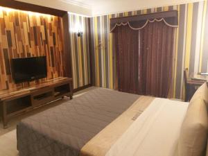 a bedroom with a bed and a flat screen tv at CHATEAU MOTEL (Crystal Code Museum) in Kaohsiung