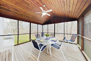 ein Esszimmer mit einem Tisch und Stühlen auf einer Terrasse in der Unterkunft Harbor Cove Cottage in Edgartown