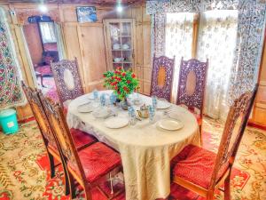a dining room with a table and chairs at Raja's Palace Houseboat - Lake View in Srinagar