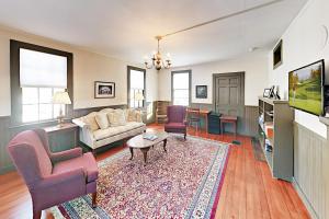 a living room with a couch and chairs and a tv at Nickels-Sortwell House in Wiscasset