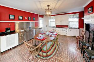 a kitchen with red walls and a table and chairs at Nickels-Sortwell House in Wiscasset