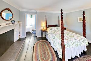 Schlafzimmer mit einem Bett, einem Kamin und einem Spiegel in der Unterkunft Nickels-Sortwell House in Wiscasset
