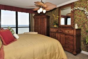 a bedroom with a bed and a dresser and a mirror at Golden Sands XII in Ocean City
