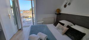 Schlafzimmer mit einem Bett und Meerblick in der Unterkunft Hotel De L'Europe in Perros-Guirec