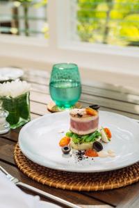 Nyne Hotels - Lake Lodge, Colombo في كولومبو: صحن مع ساندويتش على طاولة مع كوب