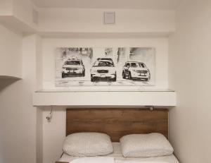 une photo de trois voitures sur un mur au-dessus d'un lit dans l'établissement Bachelor Apartment, à Budapest