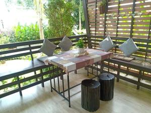 einen Tisch mit Kissen auf einer Veranda in der Unterkunft Seabreeze Cottage in Ko Chang