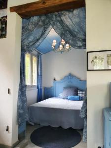a bedroom with a blue bed with a blue canopy at Maison charmante à Montfermier avec piscine privée in Montfermier