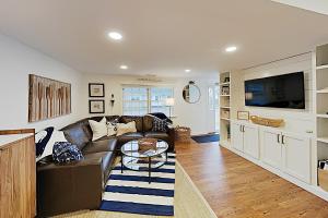 法尔茅斯Harbortown Hideaway的客厅里有一张沙发和一台电视