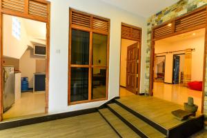 uma sala de estar com pisos em madeira e janelas grandes em 2b1 weligama em Weligama
