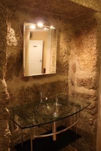 a bathroom with a glass sink and a mirror at Casa de Campo Monte Abades in Terras de Bouro